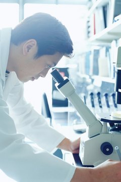 Research scientist looking into microscope, side view