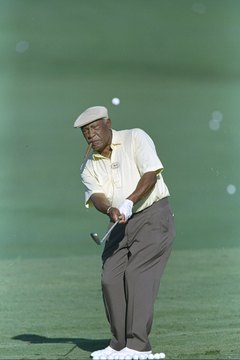 Charlie Sifford, puffing on his trademark cigar, plays a shot during the 1997 Senior PGA Championship.