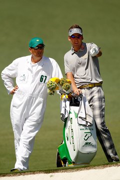 Caddie Terry Mundy (left) helps Ian Poulter plan a shot during the 2012 Masters.