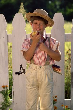 Boy in front of white picket fence