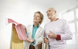 altrendo images/Stockbyte/Getty Images Los diseñadores de interiores ayudan a los clientes a seleccionar los tratamientos de paredes, muebles y decoración.