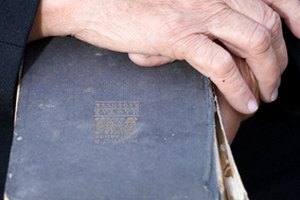 Senior's hands on old book image by Kavita from Fotolia.com Repair