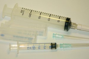 La terapia percutánea involucra una jeringa de solución salina y una jeringa para eliminar el líquido.