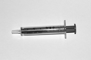 Llena la jeringa de bulbo con agua tibia y viértela en tu oído para eliminar la cera del oído que se ha aflojado por el peróxido de hidrógeno.