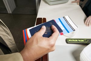Close Up on a Man's Hand Holding a Passport and Airline Ticket