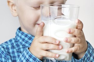Joven niño sosteniendo un vaso de leche.