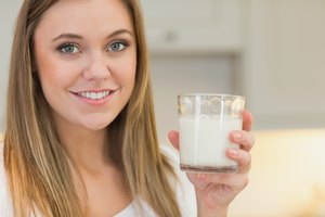 Mujer sosteniendo un vaso de leche.