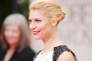 La actriz Claire Danes sonríe usando un color rosa brillante de labios en los Globos de Oro 2012.