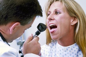 Doctor revisando la garganta de una mujer.