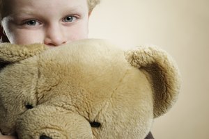 Portrait of a 6 year old boy hugging teddy bear
