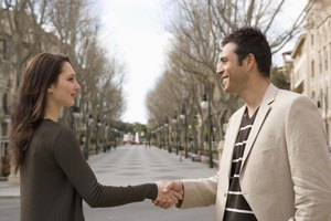 Man and woman shaking hands outdoors in city