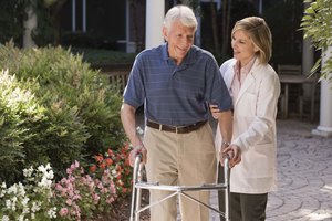 Doctor helping elderly man with walker outdoors