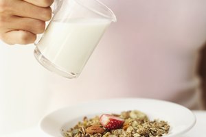 Una mujer añade leche sin grasa sobre cereal.