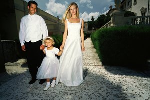 shot of a bride and groom walking in a garden with a girl (6)