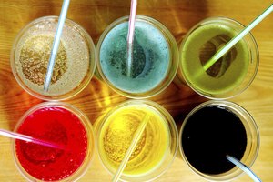 Una vista de ángulo alto de la soda de varios colores en vasos con pajitas.