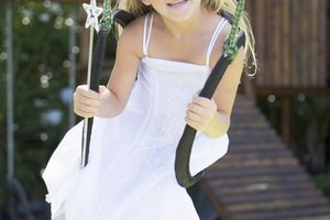 Girl in fairy princess costume sitting in swing