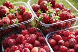 Frutillas y frambuesas en envases plásticos.