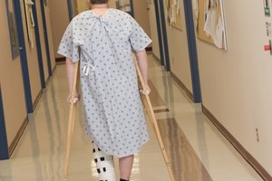 Rear view of a man in hospital on crutches