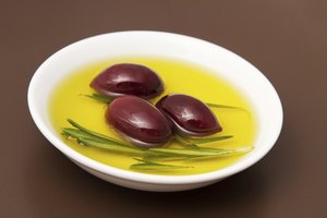 Un recipiente con aceite de oliva y aceitunas encurtidas.