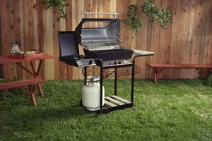 Jupiterimages/Stockbyte/Getty Images Adding woodchips to your propane grill can help simulate the deliciously smoky flavors of cooking over a traditional open wood fire.
