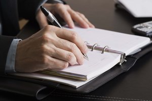 Businessperson writing in date book