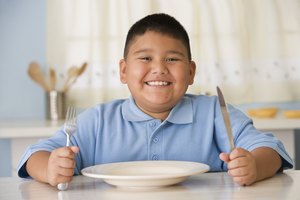 Un niño espera que le sirvan de comer
