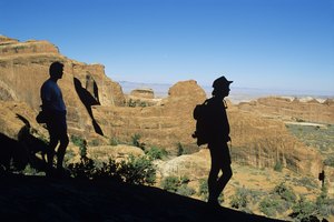 Los caminantes se detienen a ver el paisaje en el Arches National Park.