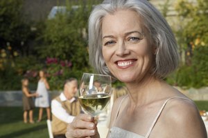 Mujer sosteniendo una copa de zinfandel blanco.