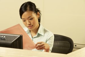 Woman reading paperwork at desk, head and shoulders