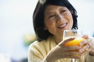 Mujer bebiendo un vaso de jugo de naranja.