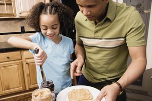 African father and daughter making peanut butter and jelly sandwich
