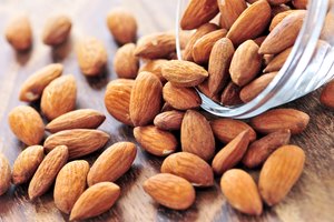 Almendras derramándose desde un recipiente de vidrio.