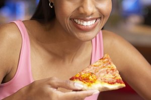Una rebanada típica de 14 pulgadas (35.56 cm) de pizza de queso con corteza normal contiene entre 250 y 350 calorías y 10 y 17 gramos de grasa.