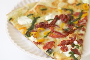 La salsa de jitomate y las cubiertas de carne en la pizza causan acidez antes de dormir.