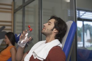 Hombre bebiendo agua en un gimnasio.