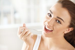 Mujer comiendo yogurt.