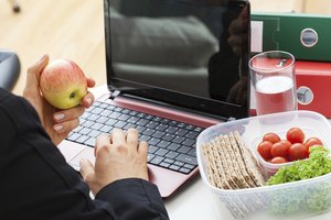 Una persona almorzando mientras trabaja en la oficina