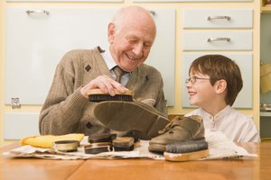 Grandfather and grandson shining shoes