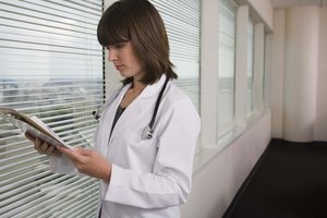 Doctor mirando los resultados en el portapapeles.