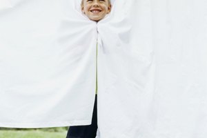 Imagen de un niño sonriendo entre sabanas blancas