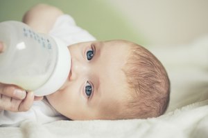 Bebé tomando biberón de leche.