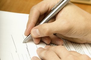 Person writing on contract, close-up, tilt