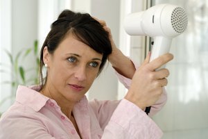 Mujer secándose el pelo después de lavarlo.