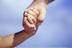 Father and son (4-5) holding hands, Close-up of hands