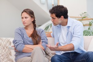 Una pareja tiene una discusión en casa en el sofá.