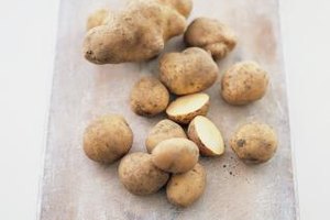 Digital Vision./Photodisc/Getty Images Once you've cut a potato, the oxygen in the air interacts with its carbohydrates and darkens the flesh.