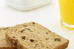 Rebanadas de pan integral y un vaso con jugo de naranja