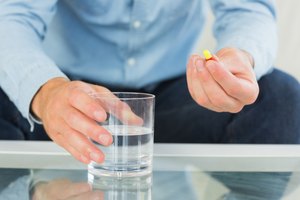 Un hombre a punto de tomar un medicamento en píldoras