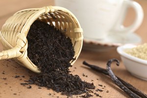 Té negro suelto con taza y granos de vainilla.
