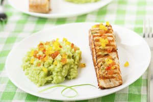 Un filete asado de salmón servido con risotto de aguacate y salsa de tomate mango.